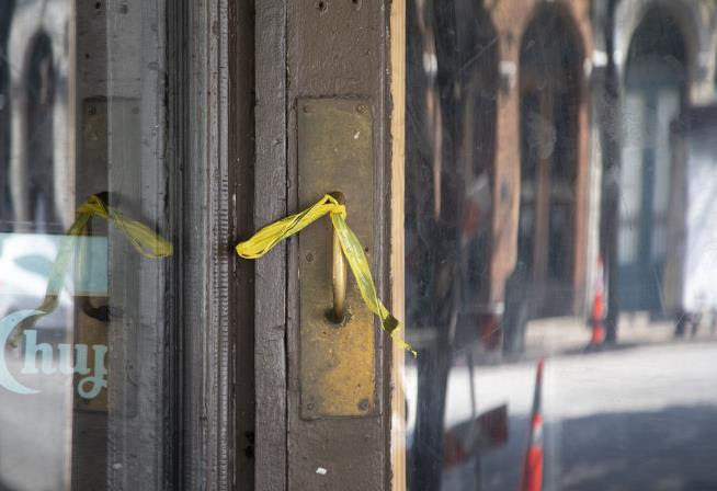 Caution tape is wrapped around a restaurant's door handle after a mass shooting
