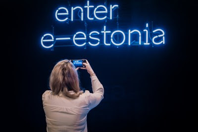 Woman taking photos of enter e-estonia sign Woman taking photos of enter e-estonia sign