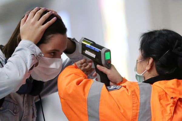 Checking the temperature of a passenger arriving at the international airport in Hong Kong. The city, like Singapore and Taiwan, has made headway in containing Covid-19.