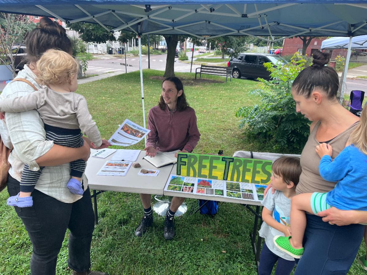 Braden DeForge at the ONE Farmers Market helping residents sign up for trees.