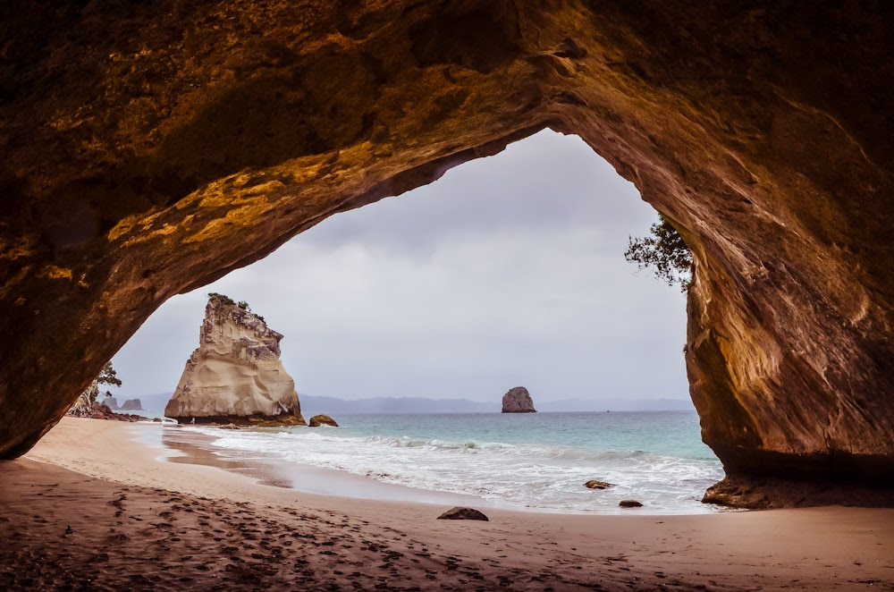 sea waves on shore through arch cave