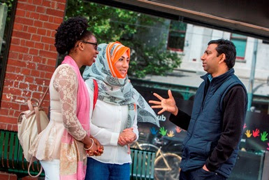 A man talking to two women.