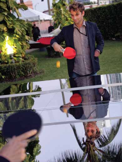 Rirkrit Tiravanija. Untitled 2008 (The Future will be Chrome). Polished Stainless Steel Ping-Pong Table, Shown Here with Artists Jay Nelson, Right, and Annie Wachmicki, Obscured, Playing Ping-Pong During a NADA Preview at The Ice Palace in Miami, on December 2, 2008.