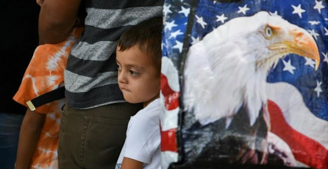 Un niño migrante de Guatemala de cinco años y su familia esperan con otros solicitantes de asilo, liberados tras ser detenidos en la frontera de EEUU con México.- REUTERS