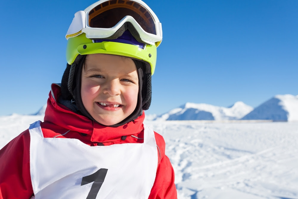 Happy little skier in safety helmet and goggles