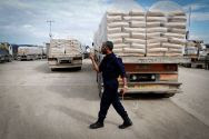 A Hamas policeman walks past trucks loaded with cement which enter Gaza from Israel through the Kerem Shalom crossing. (Archive: January 2015)