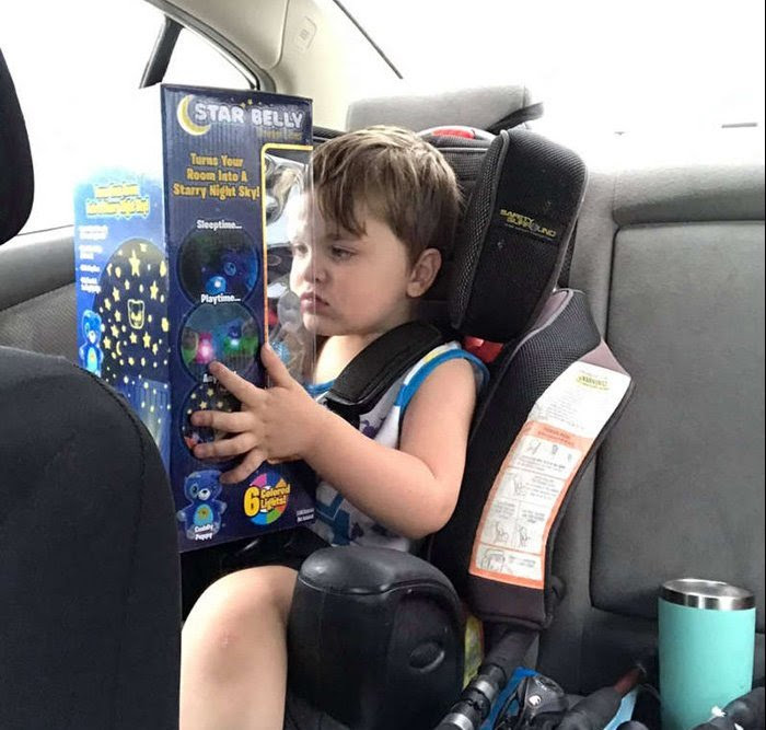 A child in a car seat holding a toy A child in a car seat holding a toy