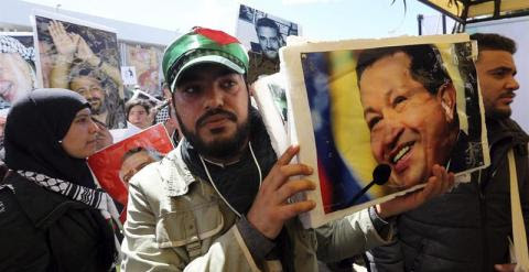 Un hombre sostiene el retrato del ex presidente venezolano Hugo Chávez a su llegada al XIII Foro Mundial Social (FMS).- EFE