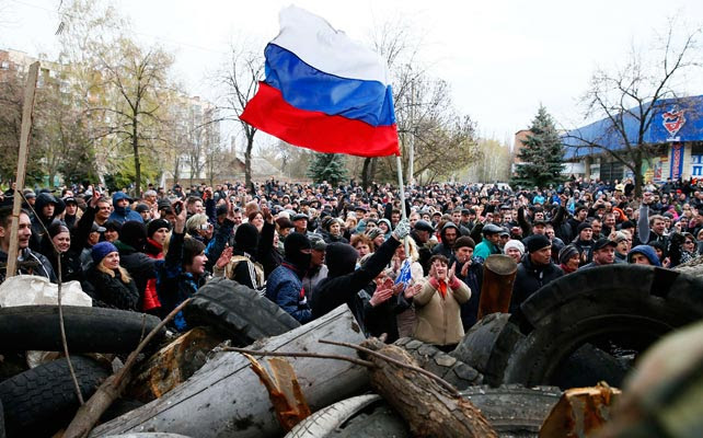 Prorrusos ondean una bandera rusa frente a la comisaría tomada en Slaviansk.