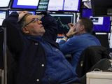 A pair of traders work in their booth on the floor of the New York Stock Exchange, Thursday, March 12, 2020. The deepening coronavirus crisis is sending stocks into another alarming slide on Wall Street, triggering a brief, automatic shutdown in trading for the second time this week. (AP Photo/Richard Drew)