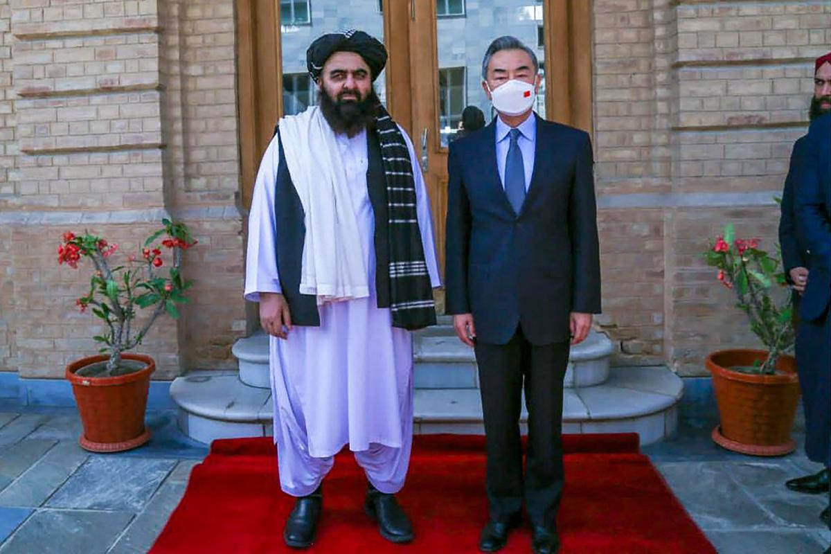 This handout photo released by the Taliban Foreign Ministry shows Taliban Foreign Minister Amir Khan Muttaqi (L) posing with China’s Foreign Minister Wang Yi in Kabul on March 24, 2022.