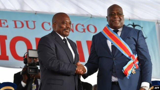 Le 24 janvier 2019, le président sortant de la République démocratique du Congo, Joseph Kabila, serre la main du président nouvellement élu, Felix Tshisekedi, après l'avoir assermenté à Kinshasa.