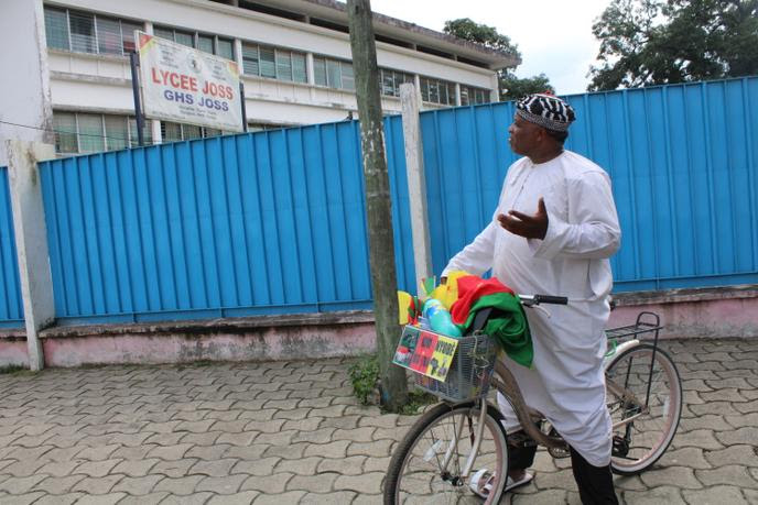 Le militant camerounais André Blaise Essama devant le lycée Joss de Douala, début juillet 2020, qu’il a tenté de faire rebaptiser lycée Ernest-Ouandié, figure de la lutte d’indépendance du Cameroun dans les années 1960.