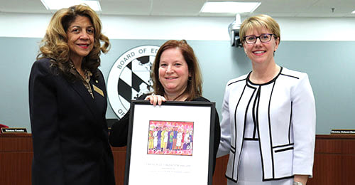 Debbie Engles being honored by the BOE Chair and the Deputy Superintendent.