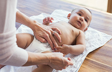 una madre cambiando los pañales de un bebé