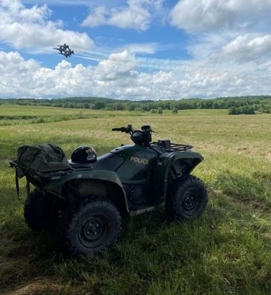 ECO ATV in a field as four jets fly over in the sky