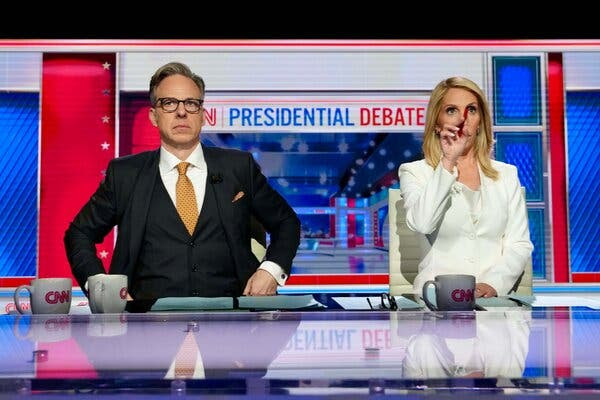 Jake Tapper, left, and Dana Bash, seated at their moderators table during the debate.