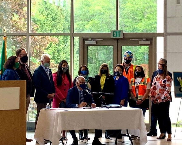 Gov. Jay Inslee signs Climate Commitment Act legislation at Shoreline Community College on May 17, 2021