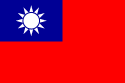 A red flag, with a small blue rectangle in the top left hand corner on which sits a white sun composed of a circle surrounded by 12 rays.