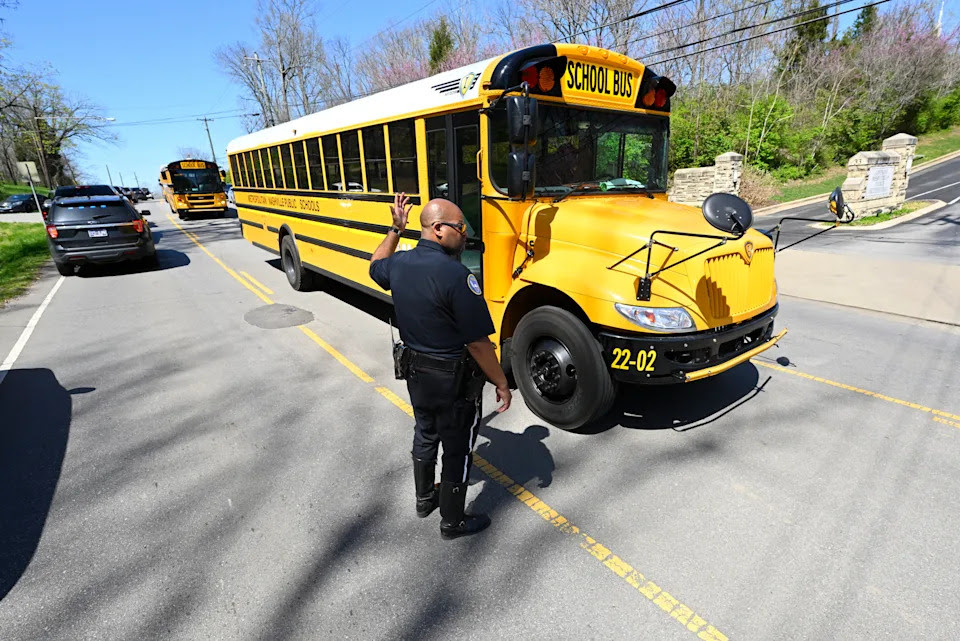 A Metro Nashville Police Department officer directs school buses carrying evacuees from the church and school outside of Covenant School, Covenant Presbyterian Church, in Nashville, Tenn. Monday, March 27, 2023. Officials say several children were killed in a shooting at the private Christian grade school in Nashville. The suspect is dead after a confrontation with police. (AP Photo/John Amis)