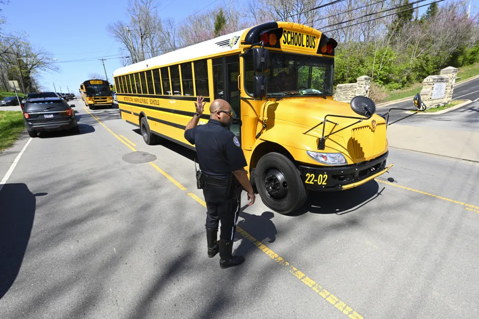 A Metro Nashville Police Department officer directs school buses carrying evacuees from the church and school outside of Covenant School, Covenant Presbyterian Church, in Nashville, Tenn. Monday, March 27, 2023. Officials say several children were killed in a shooting at the private Christian grade school in Nashville. The suspect is dead after a confrontation with police. (AP Photo/John Amis)