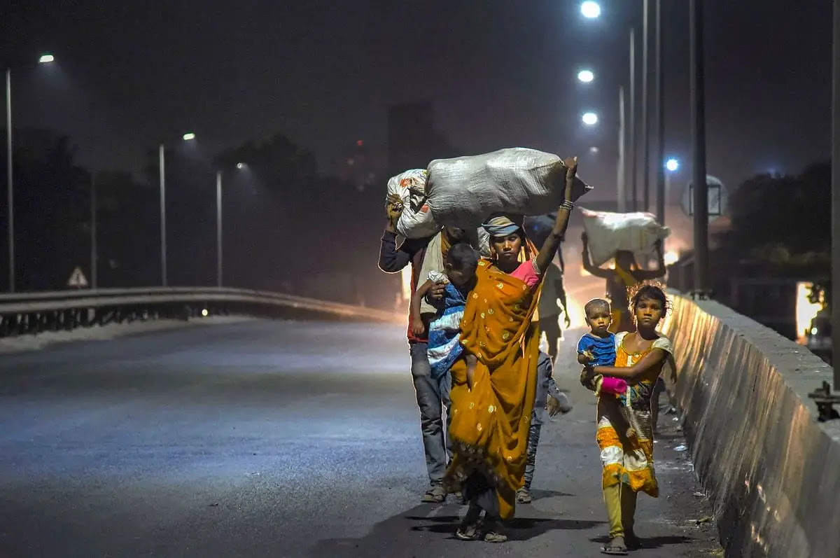 मध्य प्रदेश का एक प्रवासी परिवार नवी मुंबई में घर पहुंचने के लिए देर रात सड़क के किनारे चलते हुए.