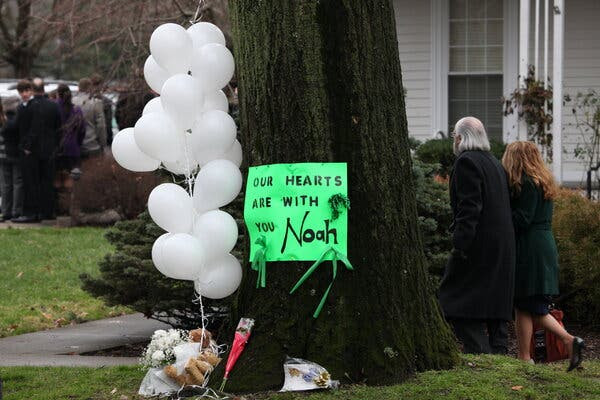 A makeshift memorial for Noah Pozner, the youngest victim of the Sandy Hook shooting, outside his funeral in 2012. Pozner's family has been harassed by conspiracy theorists.