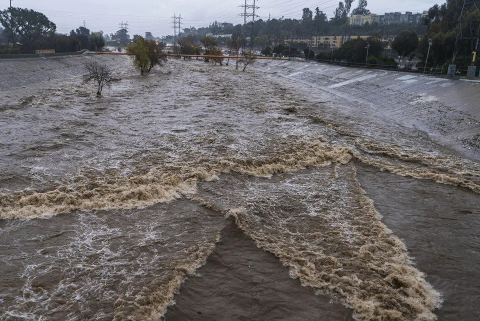 The Los Angeles River flows downstream in Los Angeles Saturday, Jan. 14, 2023. California got more wind, rain and snow on Saturday, raising flooding concerns, causing power outages and making travel dangerous. (AP Photo/Damian Dovarganes)