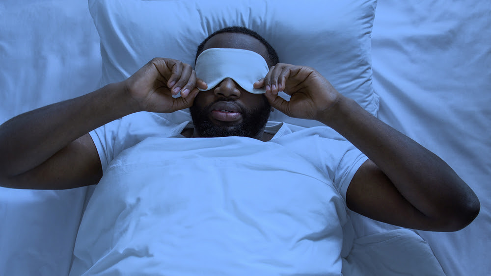 man in bed with an eye mask