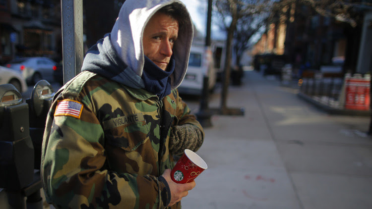 Chris, un veterano estadounidense de guerras en Irak y Afganistán sin techo, pidiendo dinero en una calle de Boston.