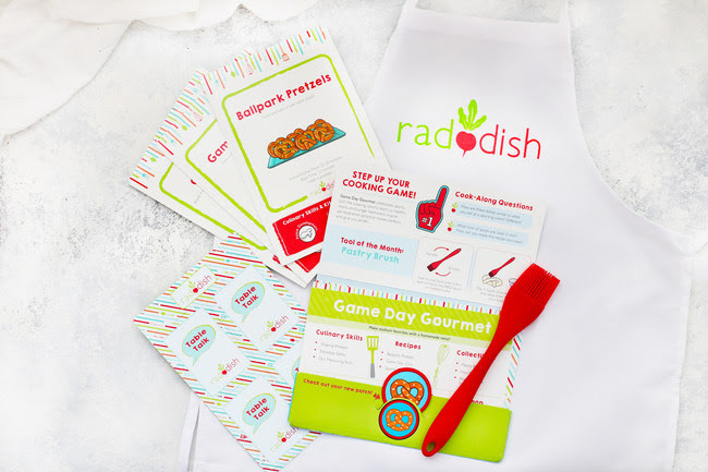 The new Raddish folder introduces the kit's theme, stores all of the kit's contents, displays the collectible apron patch, announces the tool of the month, features games/activities and shares how to access "Bonus Bites"-the expansive library of free online content.