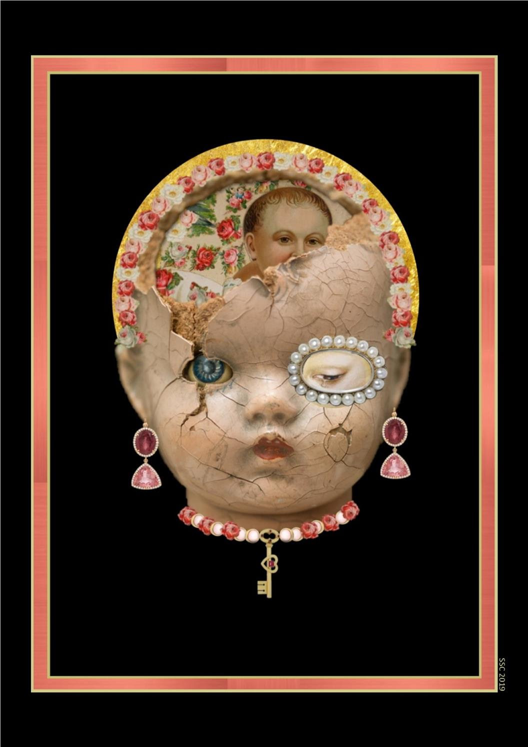 Face of a doll on a black background framed by a rectangular pink frame. The doll’s face is cracked and collaged over with decorative roses and pearls, the doll is wearing hanging gem earrings and a necklace decorated with a heart shaped key.