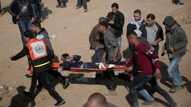Evacuating a wounded Palestinian during Friday's clashes (Photo: AP)