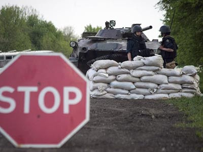 Activistas prorrusos armados hacían guardia en un improvisado puesto de control en Slaviansk,