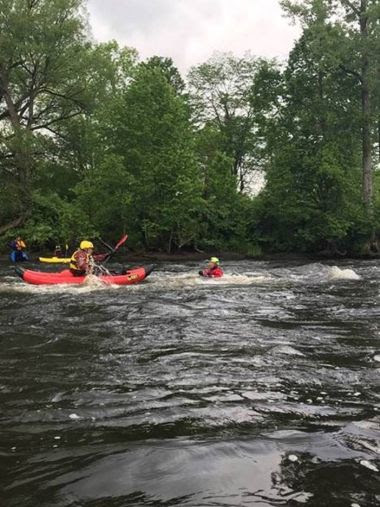 Forest Rangers and instructors paddling kayaks in water