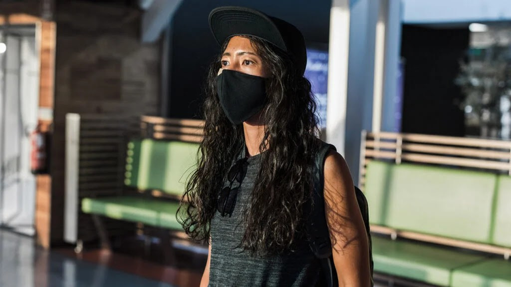 woman standing wearing black mask