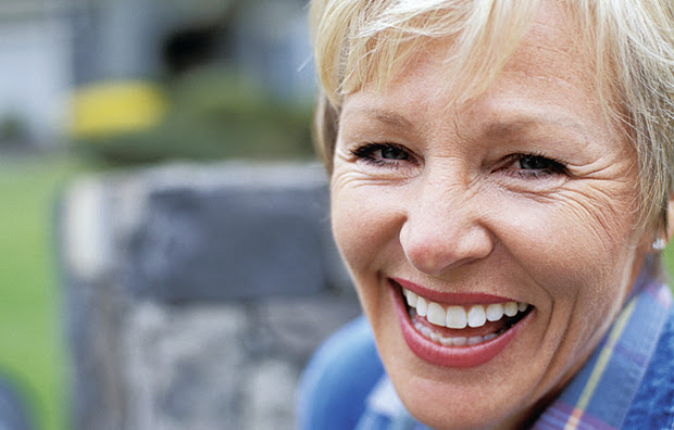 A mature woman smiling.