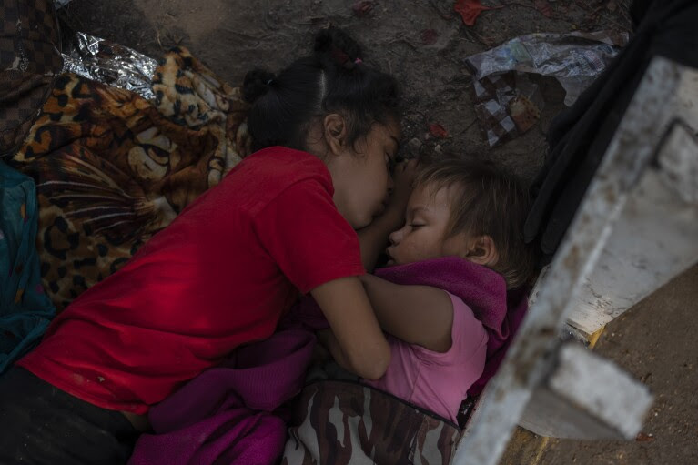 The Bolaños sisters from Venezuela, Kamila, left, and Brigitte, sleep on the ground outside a bus terminal where they are living with their single mother Keilly and two other siblings, alongside other migrants in Villahermosa, Mexico, Saturday, June 8, 2024. Their mother said she was seeking asylum hoping to treat her her four-year-old daughter, Brigitte, for leukemia, due to lack of access to medical care back in Venezuela. (AP Photo/Felix Marquez)