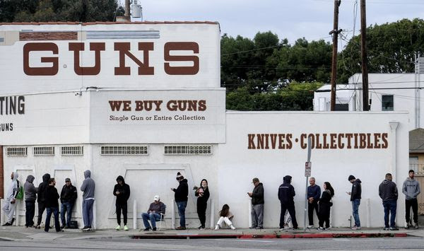 In this March 15, 2020, file photo, people wait in line to enter a gun store in Culver City, Calif. (AP Photo/Ringo H.W. Chiu, File)