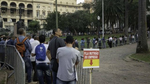 Pessoas aguardam numa enorme fila de um mutirão de emprego