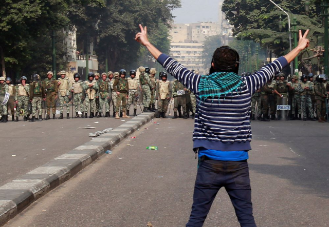 A protester flashes a victory sign in front of a line of army soldiers near the cabinet in Cairo December 16, 2011. REUTERS/Asmaa Waguih