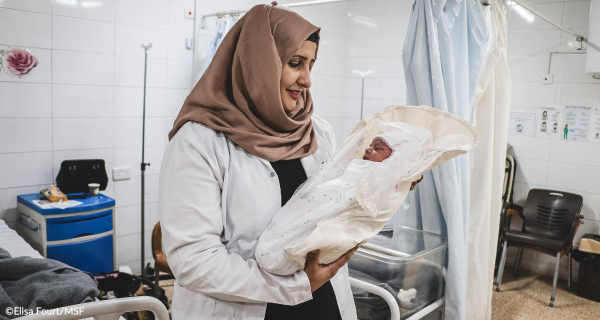 Rahma, supervisora de comadronas, sostiene a un recién nacido llamado Rivan en la maternidad de Al-Amal, en Mosul