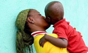 Una madre, con su hijo de dos años en brazos en Costa de Marfil, descubrió que era seropositiva durante el embarazo.