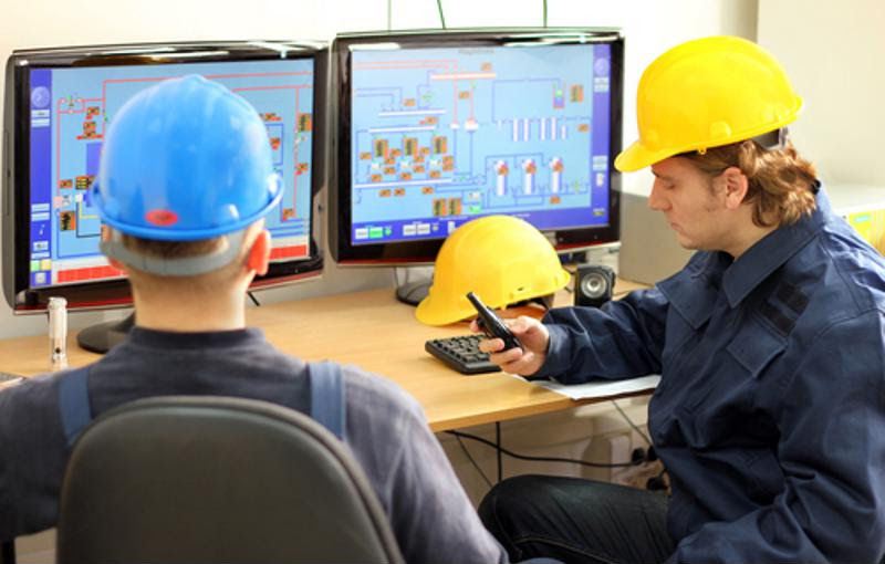 Photo of control room employee distracted by cell phone.
