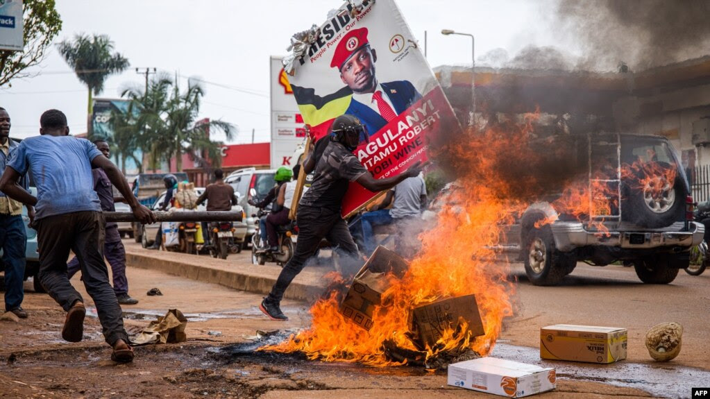 Un partisan du musicien ougandais devenu politicien Robert Kyagulanyi, également connu sous le nom de Bobi Wine, porte son affiche lors d'une manifestation contre l'arrestation de Kyagulanyi, lors de son rassemblement de campagne à Kampala, en Ouganda, le 18 novembre 2020.