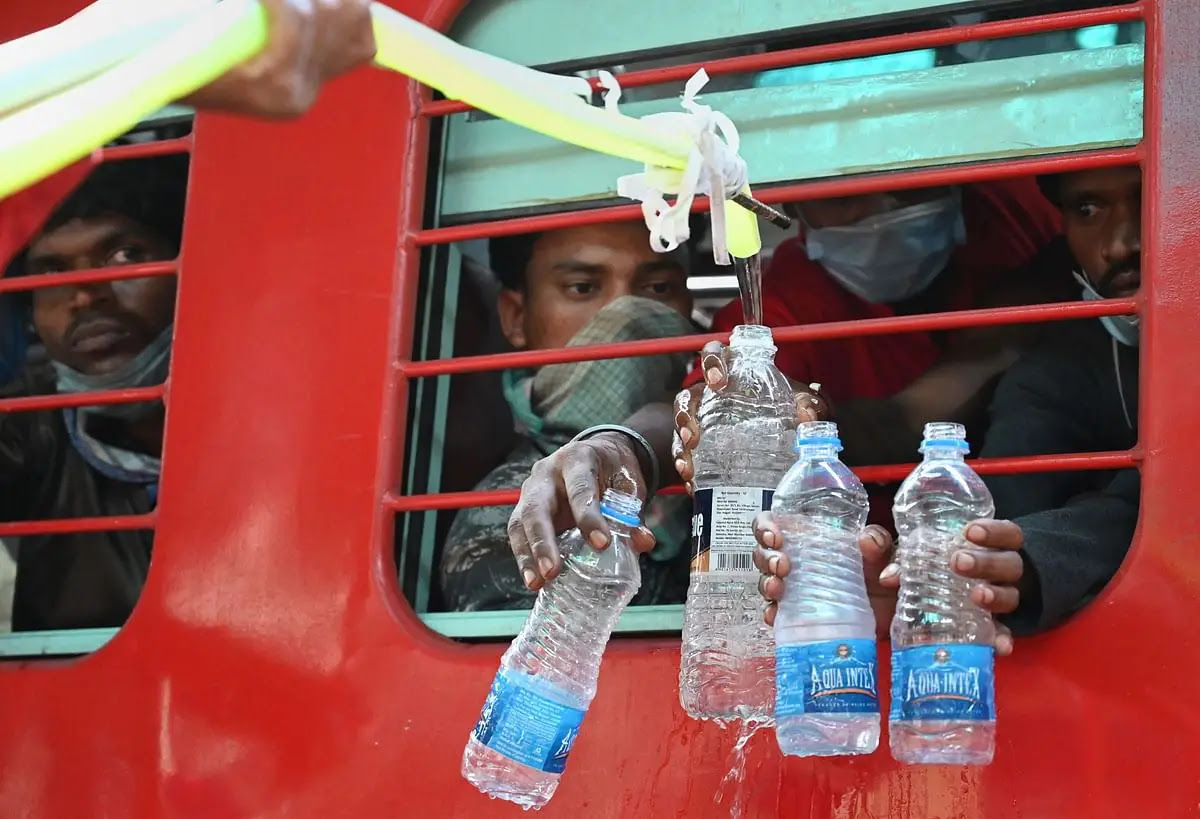 रेलवे कर्मचारी जबलपुर में ट्रेनों में यात्रा करने वाले प्रवासियों को पानी उपलब्ध कराते हुए.
