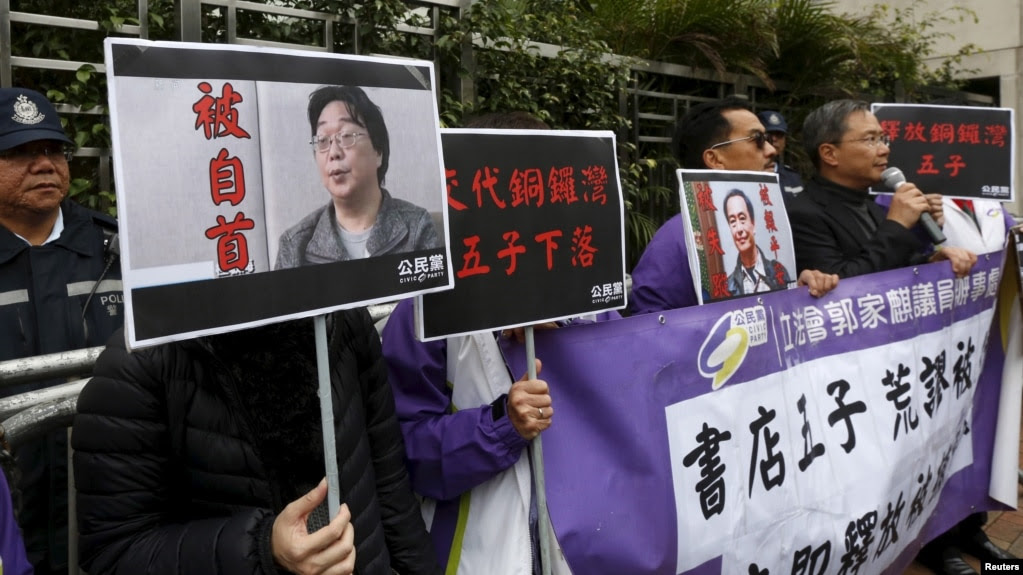 香港民主抗议者举着铜锣湾书店老板桂民海（左）和李波（右）的肖像（2016年1月19日）