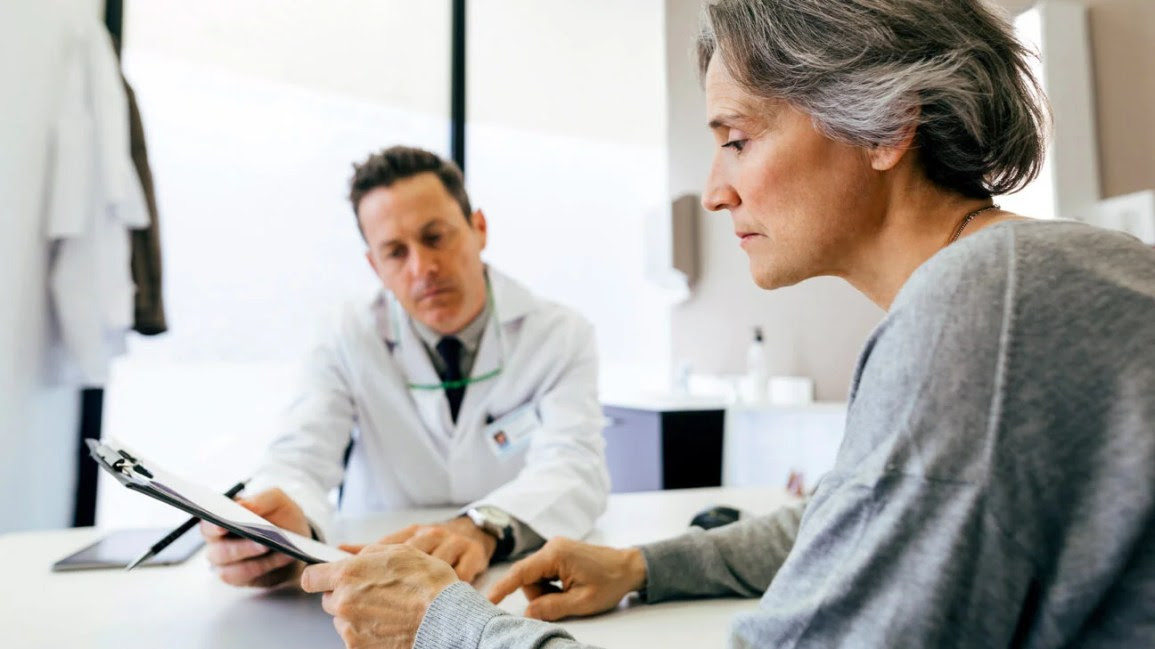 A doctor examining documents with a patient.