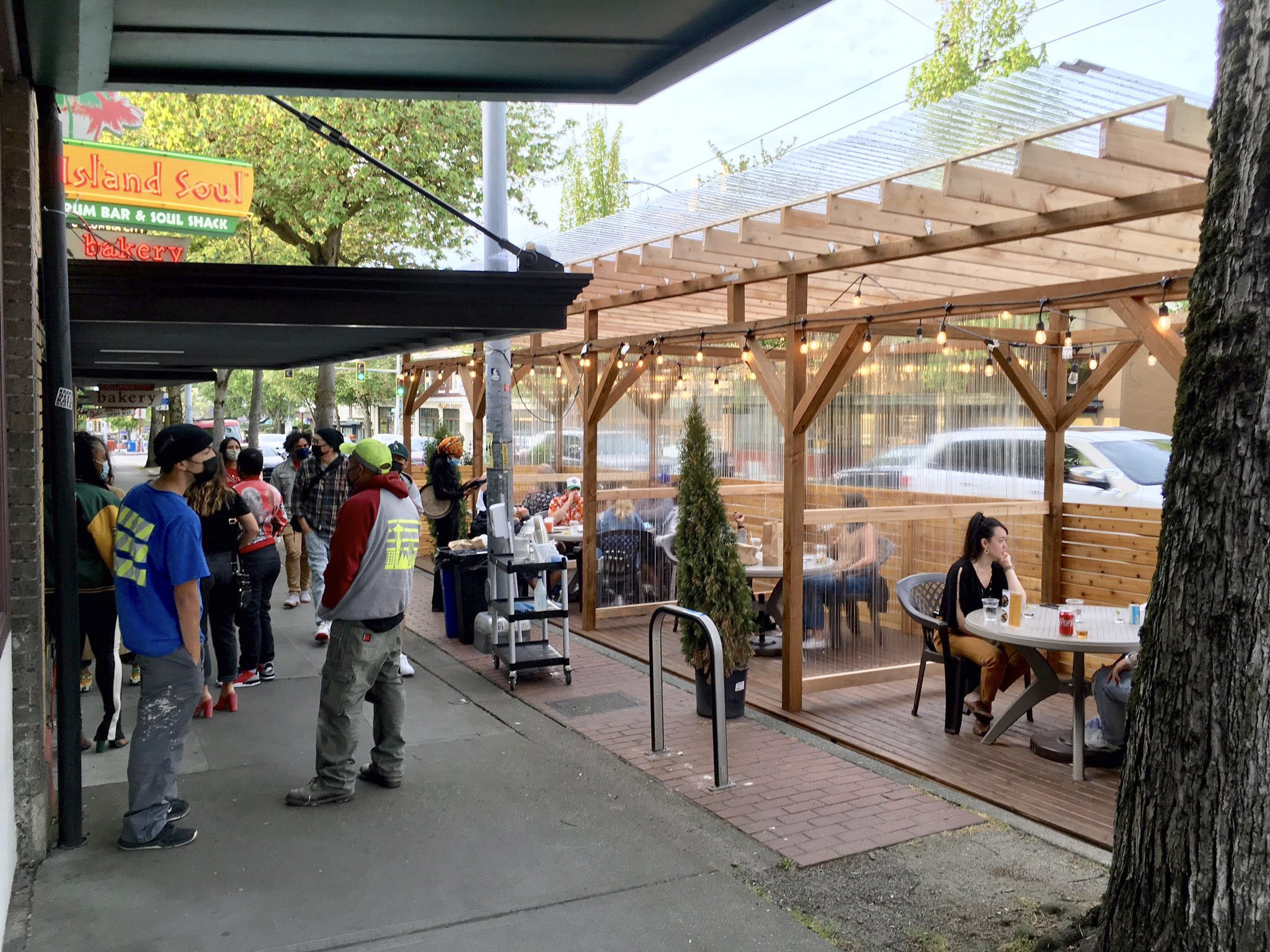 People bustling around Island Soul's Cafe Street in Columbia City.