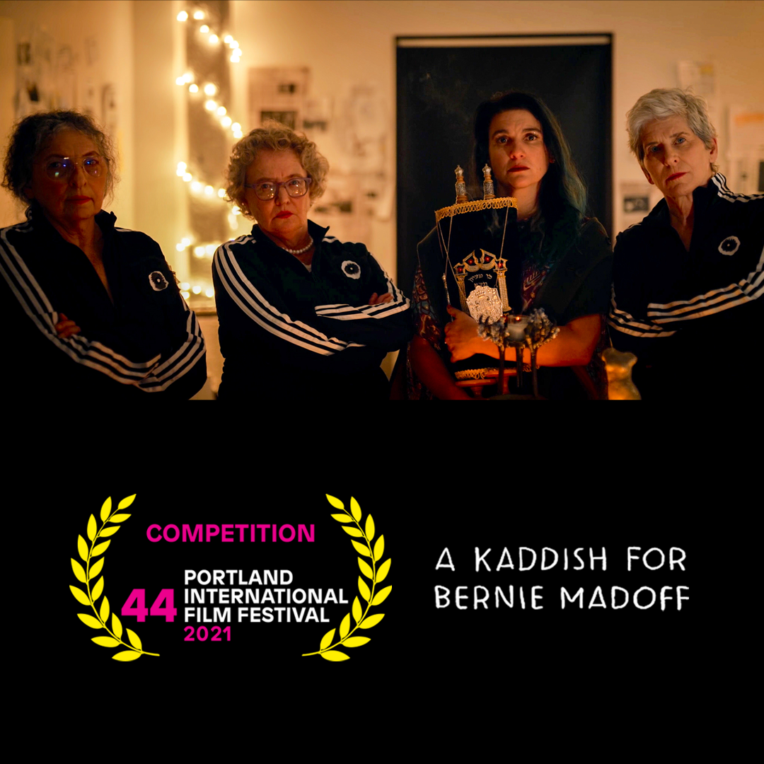 Alicia stands holding a Torah with three serious looking older women in track suits.